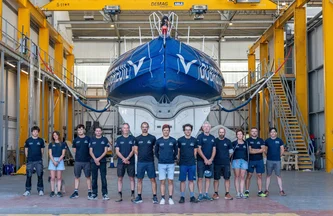 La Groupe Dubreuil Sailing Team pose fièrement face devant l'IMOCA avant sa première sortie du hangar