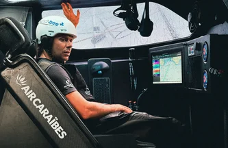 Sébastien Simon est à l'intérieur du cockpit de l'IMOCA Groupe Dubreuil 2, assis dans son siège de veille.
