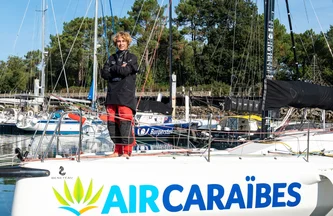 Tom Goron, en tenue de skipper, prend la pose sur le pont de son bateau