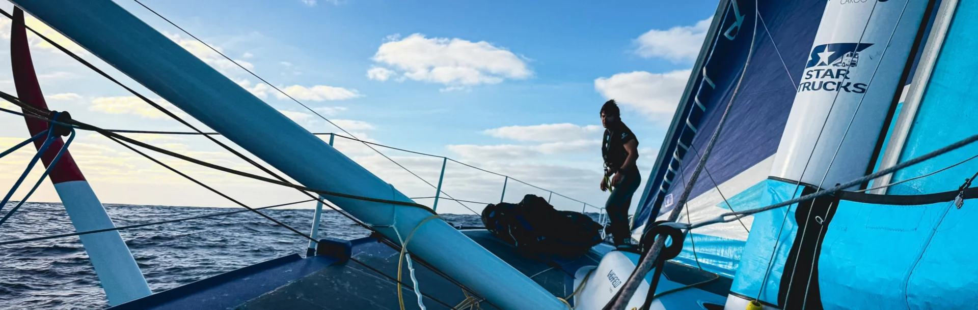 Sébastien Simon sur le pont de son IMOCA, en pleine mer.