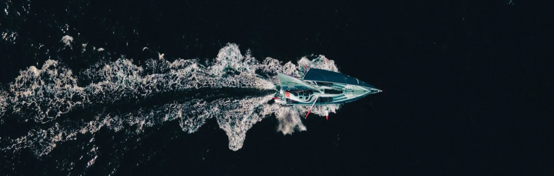 Header de l'actualité où l'on voit, du ciel, l'IMOCA Groupe Dubreuil naviguer à l'occasion du Défi Azimut